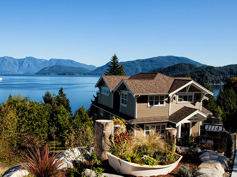 casa con arboles frente a lago