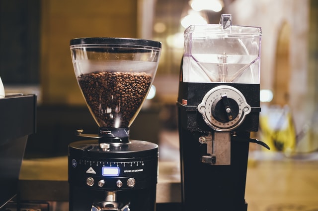 granos de cafe en una máquina de café junto al dispenser de agua de la misma máquina