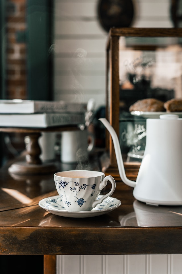 Taza de té y tetera, sobre el mostrador de la pastelería.