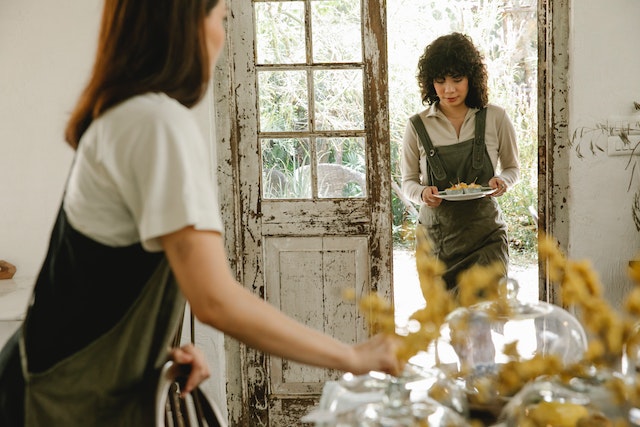 Dos mujeres acomodando una mesa.